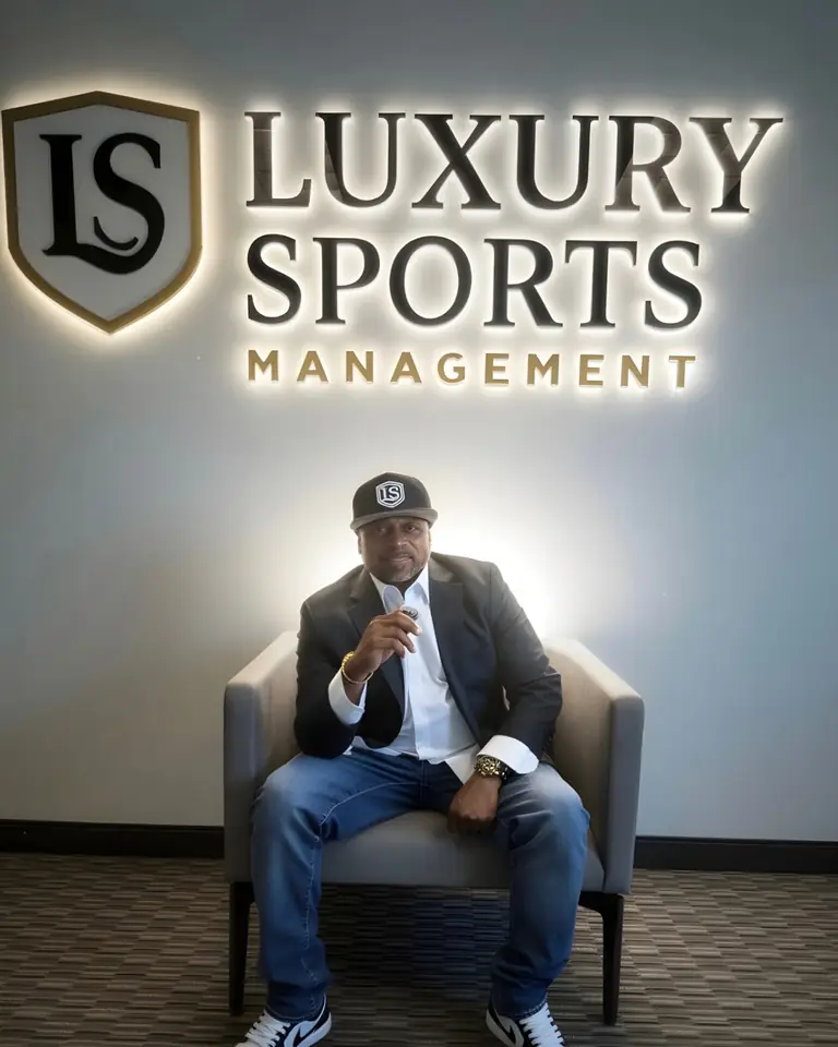 Lamont Hewitt, founder of Luxury Sports Management, seated beneath the LS crest